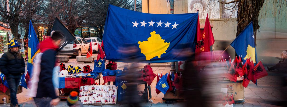 Des personnes passent devant des drapeaux du Kosovo installés dans la capitale, Pristina, le 16 février 2018.