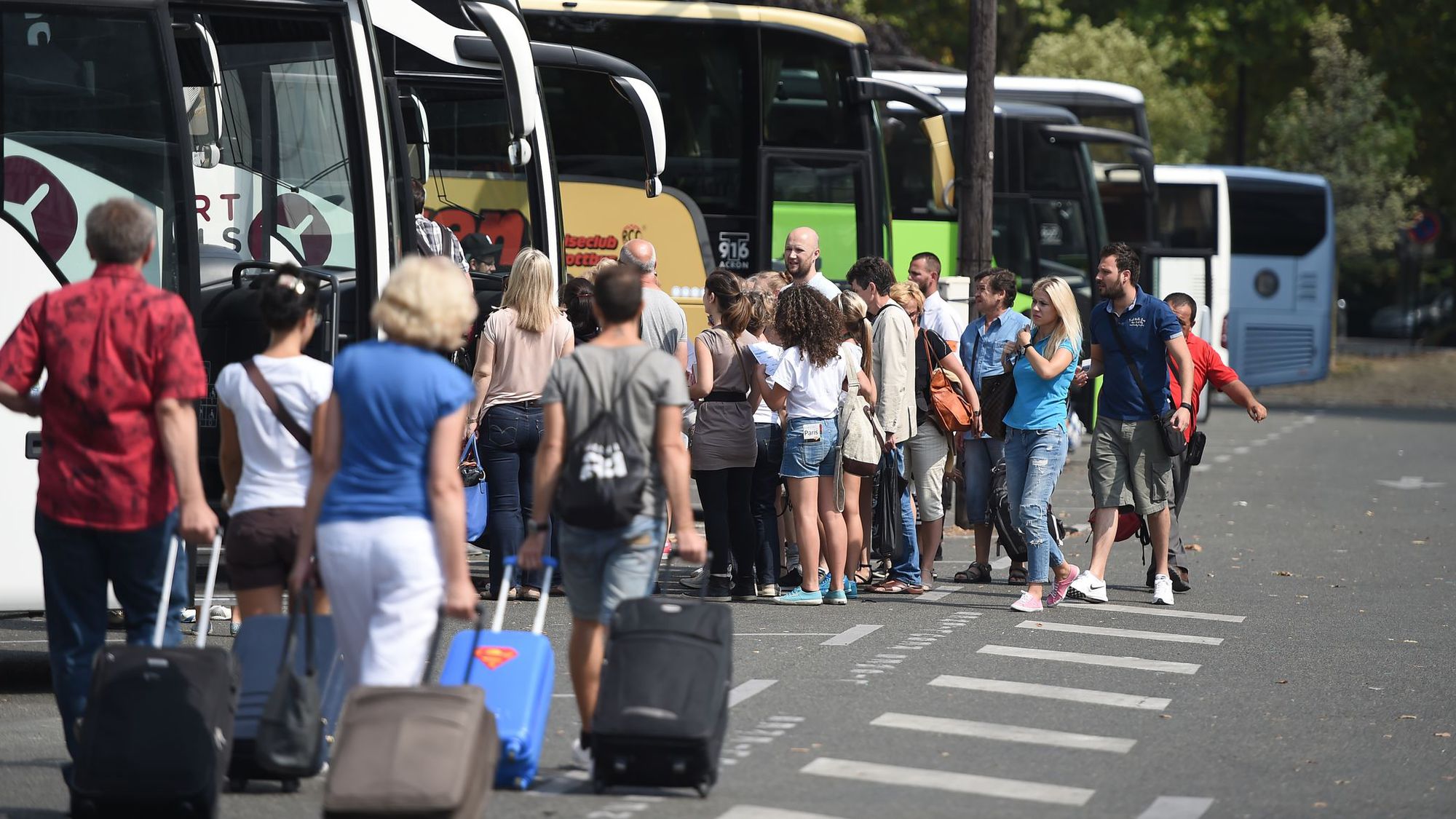 Des passagers se dirigent vers des cars Porte Maillot le 12 août 2015