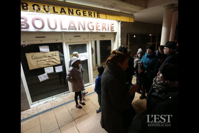 Chaque soir depuis mardi, des dizaines de clients viennent apporter leur soutien symbolique devant la boulangerie de l’Île-aux-Moineaux.  Photo Arnaud CAST
