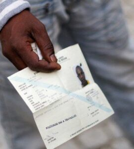 Un demandeur d’asile tenant un document de voyage