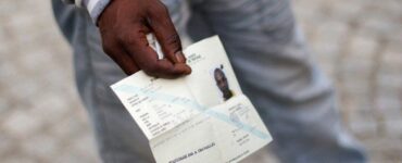 Un demandeur d’asile tenant un document de voyage