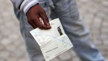 Un demandeur d’asile tenant un document de voyage