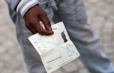 Un demandeur d’asile tenant un document de voyage