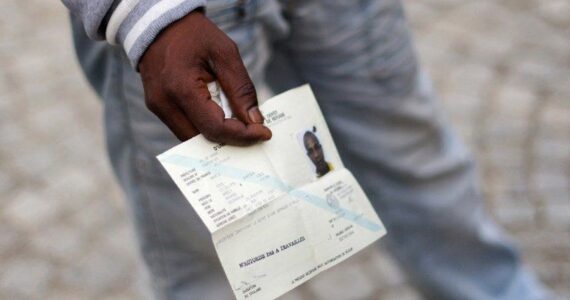 Un demandeur d’asile tenant un document de voyage
