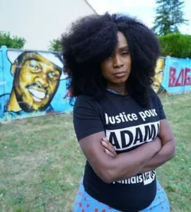 Assa Traoré devant une fresque consacrée à Adama Traoré.