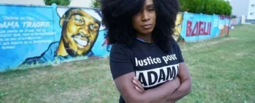 Assa Traoré devant une fresque consacrée à Adama Traoré.