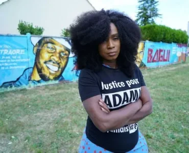 Assa Traoré devant une fresque consacrée à Adama Traoré.