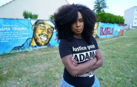 Assa Traoré devant une fresque consacrée à Adama Traoré.