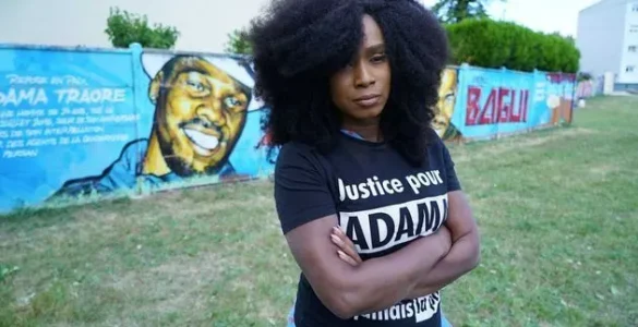 Assa Traoré devant une fresque consacrée à Adama Traoré.