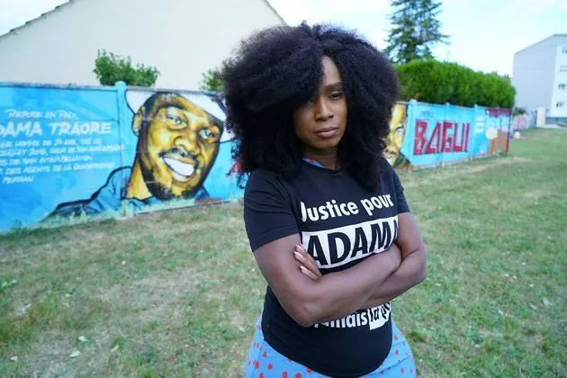 Assa Traoré devant une fresque consacrée à Adama Traoré.