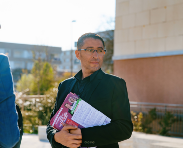Idir Boumertit distribuant des tracts pendant la campagne municipale du 19 mars 2026.