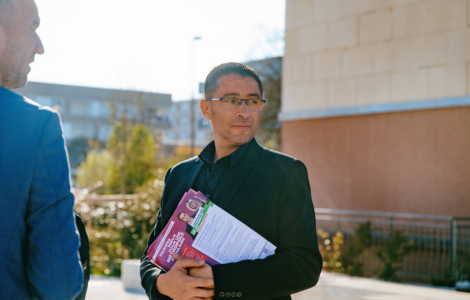 Idir Boumertit distribuant des tracts pendant la campagne municipale du 19 mars 2026.