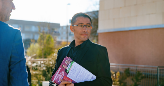 Idir Boumertit distribuant des tracts pendant la campagne municipale du 19 mars 2026.