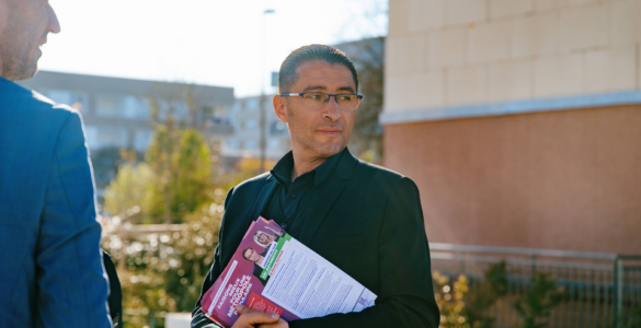 Idir Boumertit distribuant des tracts pendant la campagne municipale du 19 mars 2026.