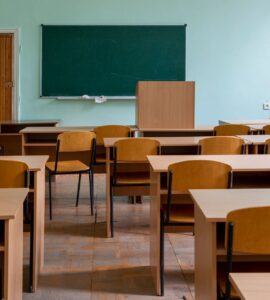 Salle de classe vide avec bureaux et tableau