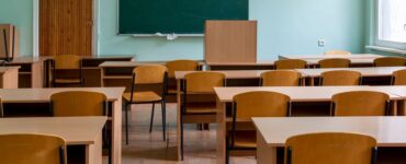 Salle de classe vide avec bureaux et tableau