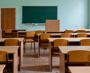 Salle de classe vide avec bureaux et tableau
