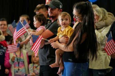 Archives : des familles sud-africaines avec des drapeaux américains à leur arrivée aux États-Unis